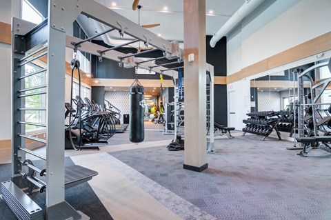 A gym with a variety of equipment including weights and cardio machines.