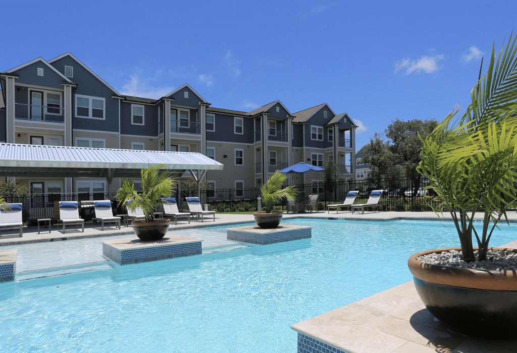 a large swimming pool with an apartment building in the background