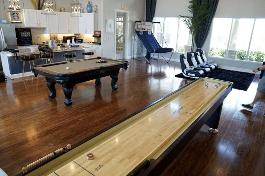a game room with a shuffleboard table and a pool table