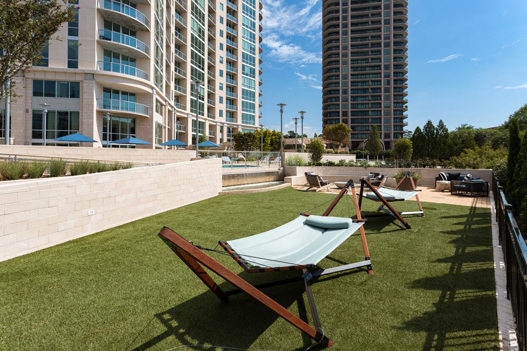 a rooftop lounge area with lounge chairs and a hammock