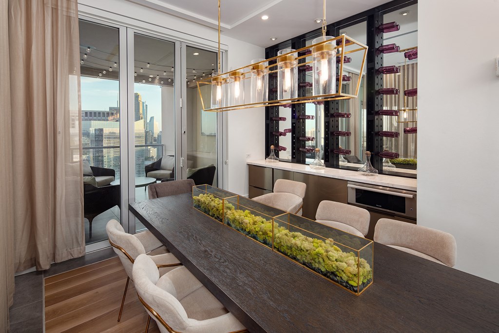 a dining room with a long wooden table and white chairs