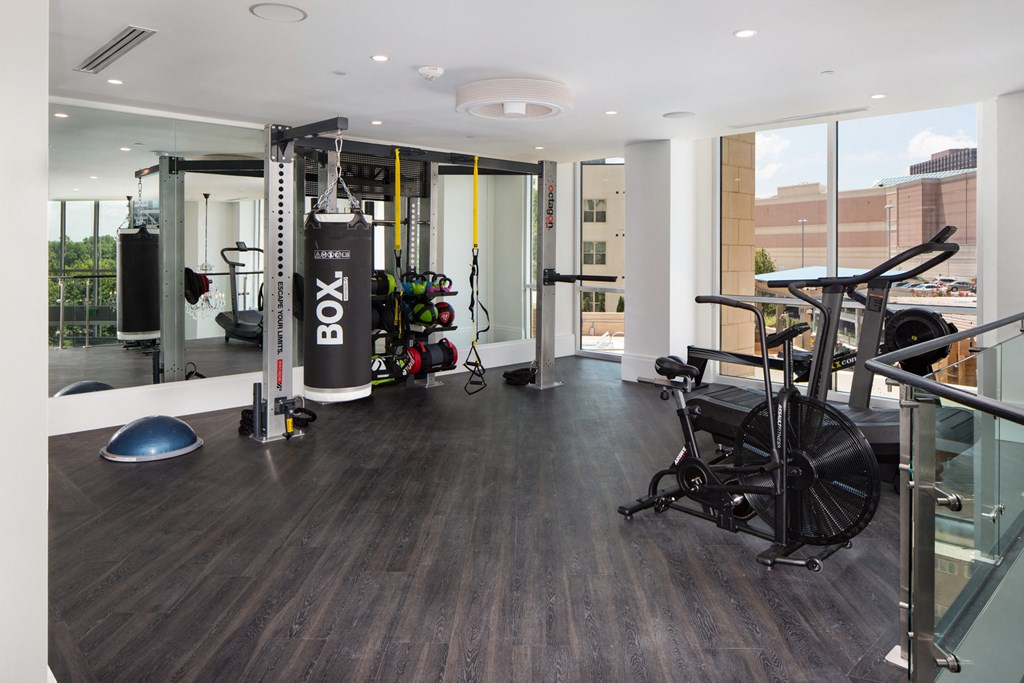 a gym with a lot of exercise equipment and a large window