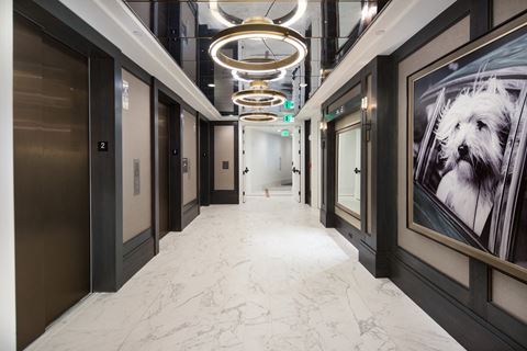 a view down a corridor in a building with black walls and white marble floors