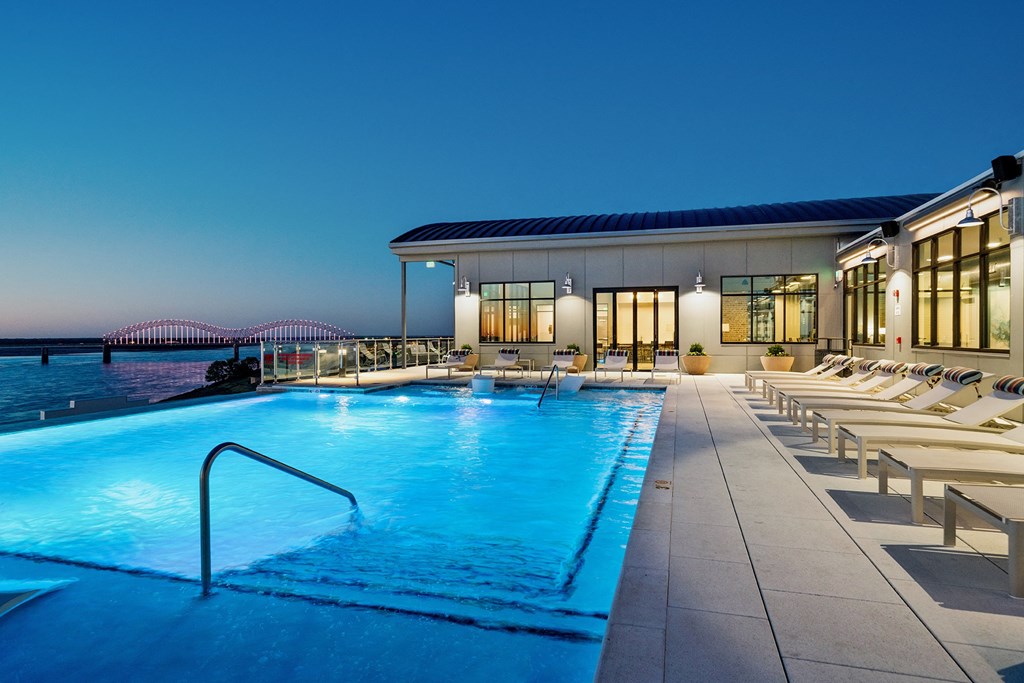 Apartments for Rent in Dowtown Memphis, TN - The Landing Residences - Rooftop Pool at Night with Lounge Chairs and View of River and Bridge