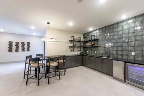 a kitchen with a bar and a table with chairs