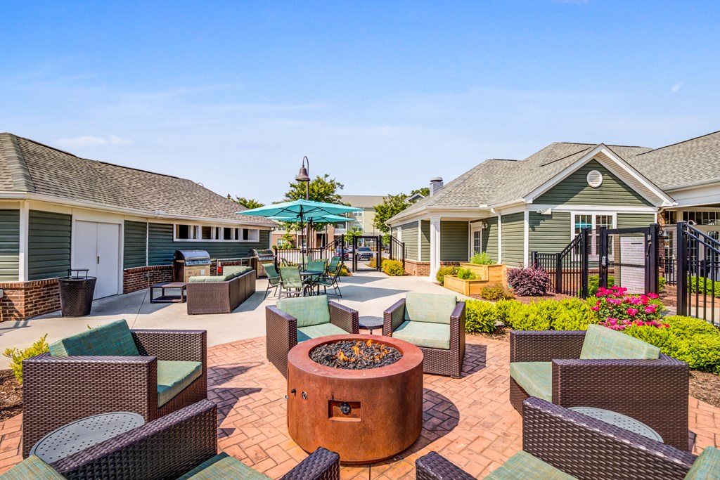 an outdoor patio with tables and chairs and a fire pit