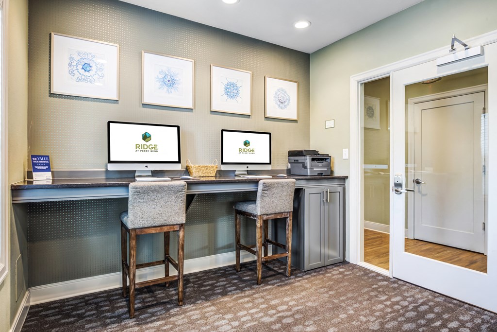 a lobby with two computers on a desk and a door