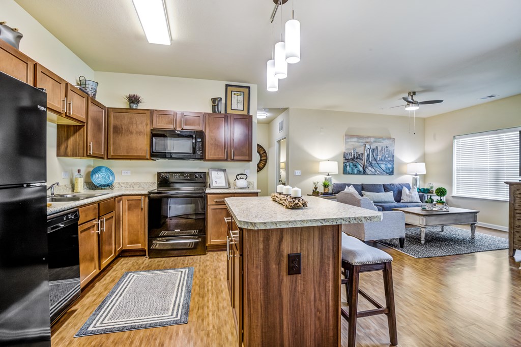 an open kitchen and living room with a large island and a living room