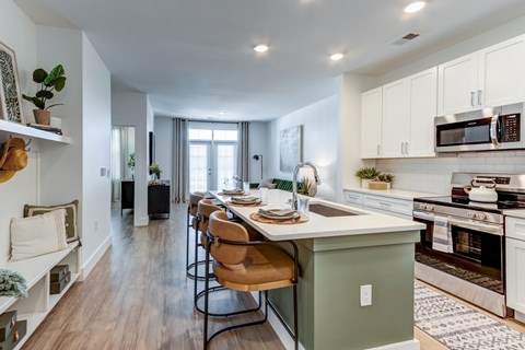 A kitchen with a table and chairs in the middle of the room.
