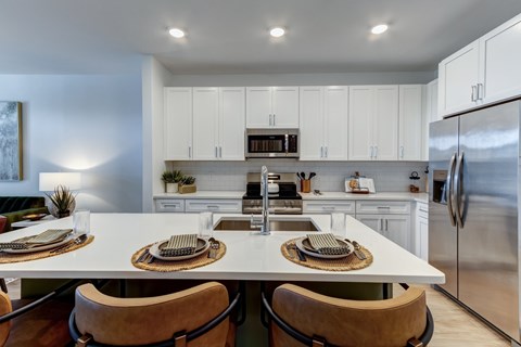 A modern kitchen with a large island and stainless steel appliances.