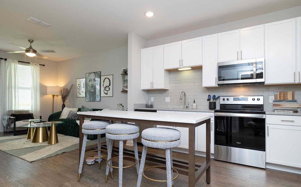 A kitchen with white cabinets and a stainless steel oven.