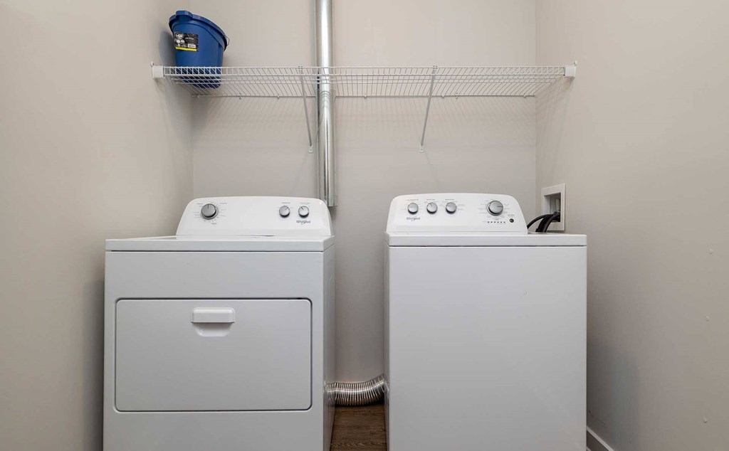 Greenville, SC, Apartments Near Clemson University - The Aster - In-Home Full-Sized White Washer and Dryer with Above White Metal Shelving.