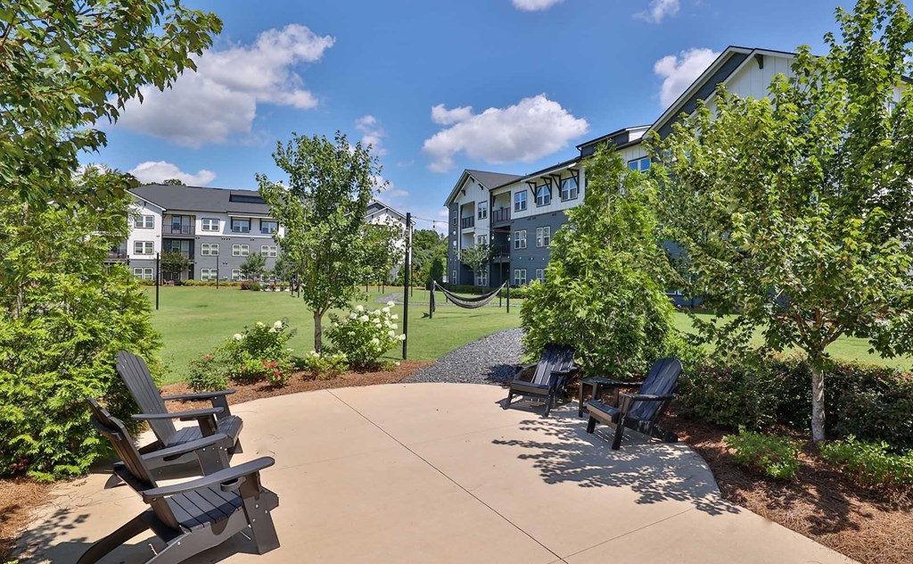 A sunny day at a park with chairs and trees.