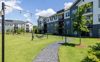 A hammock is strung between two poles in a grassy area.