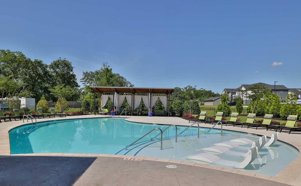 A large outdoor swimming pool with a sun lounger area.