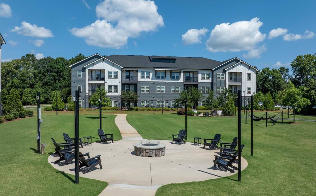 A large building with a grassy area in front and a clear blue sky above.
