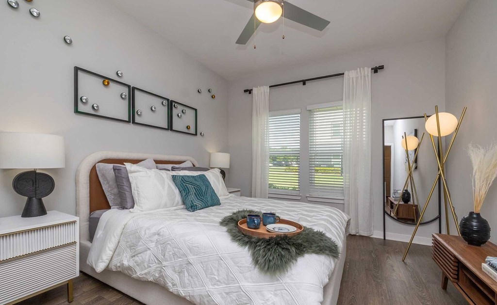 A bedroom with a large bed and a ceiling fan.