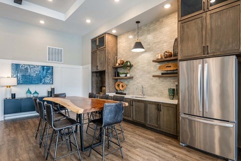 A modern kitchen with a wooden table and chairs.