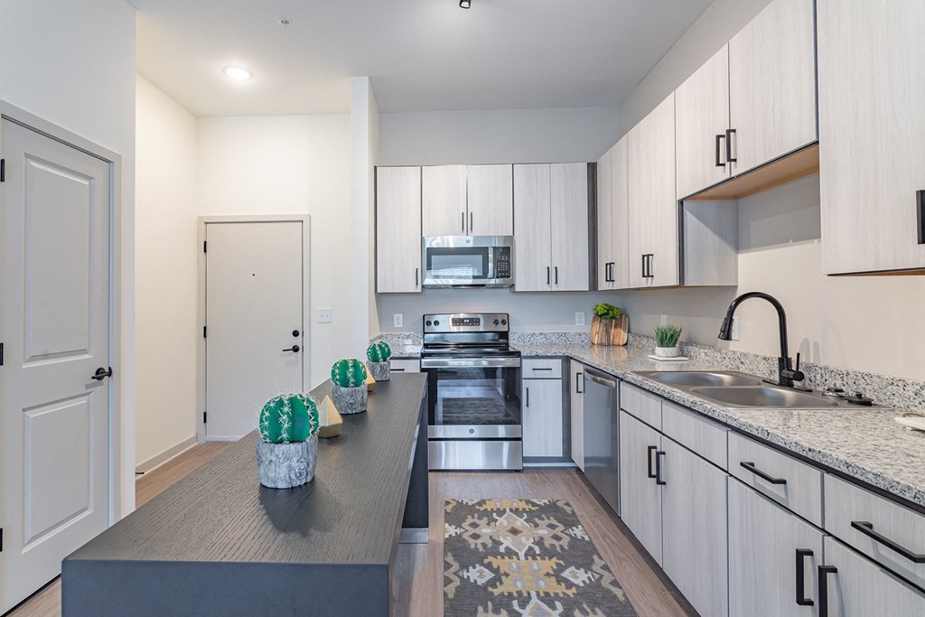 a modern kitchen with white cabinets and granite counter tops