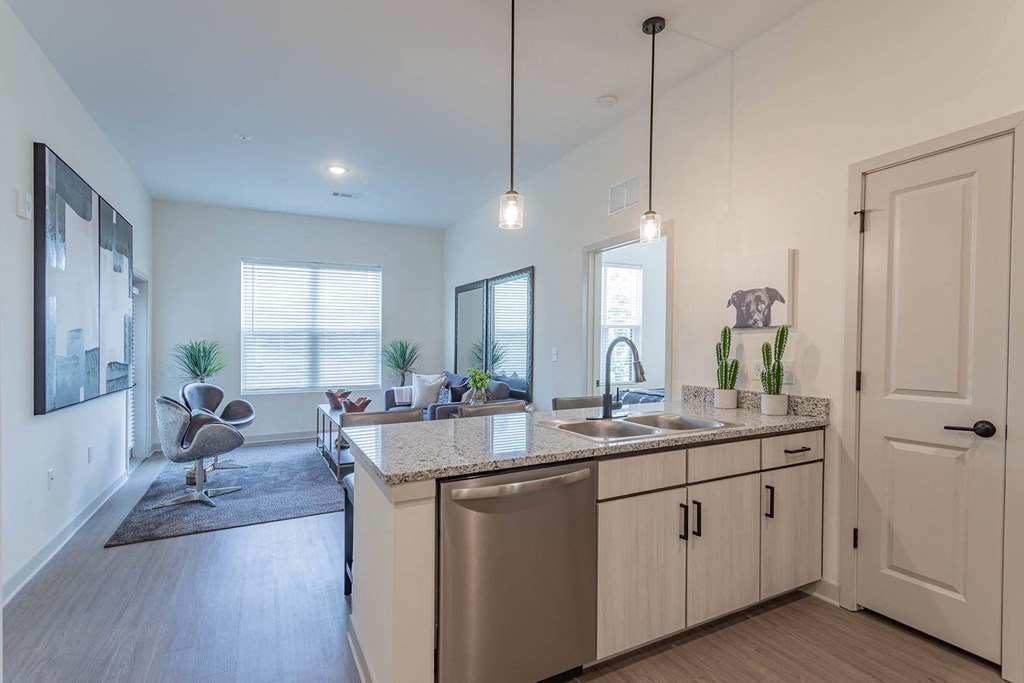 a kitchen with an island and a living room in the background
