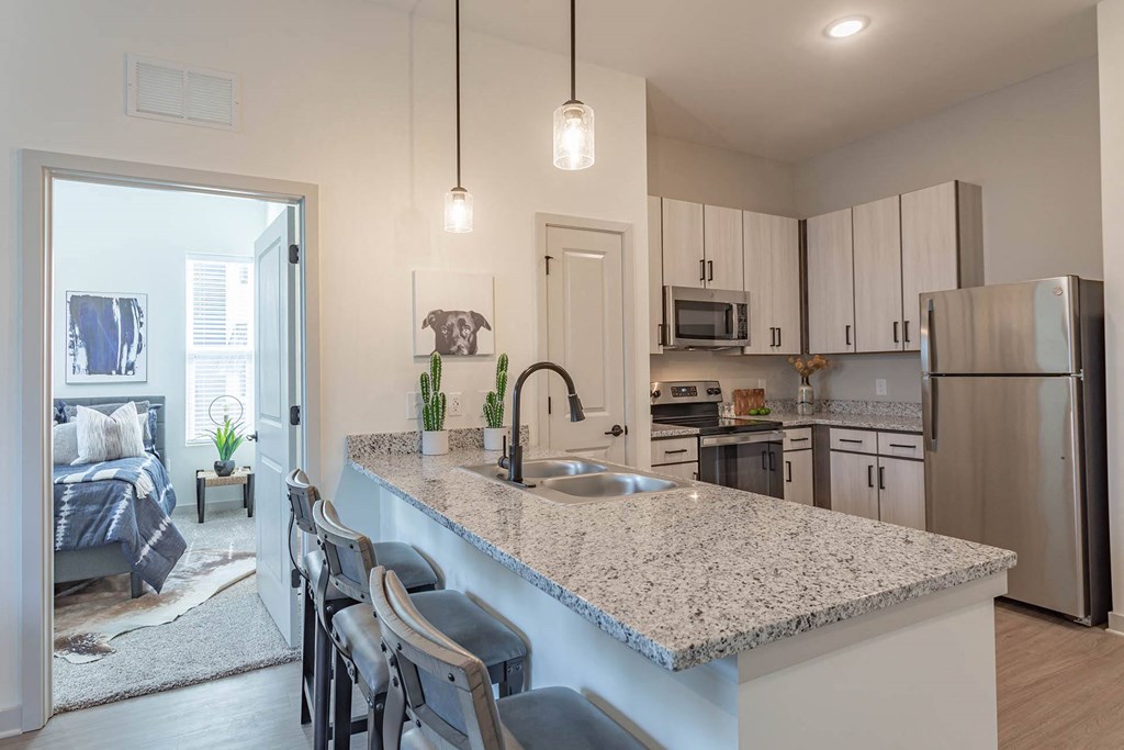 a kitchen with white cabinets and a granite counter top