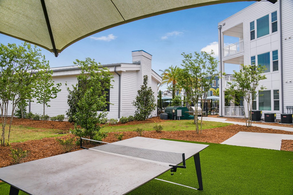 a ping pong table sits in the middle of a grassy area in front of a