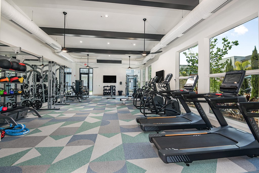 a workout room with treadmills and other exercise equipment