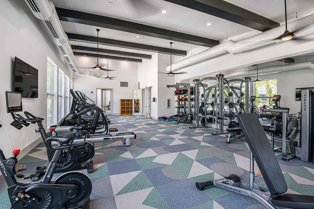 a spacious fitness center with cardio machines and weights