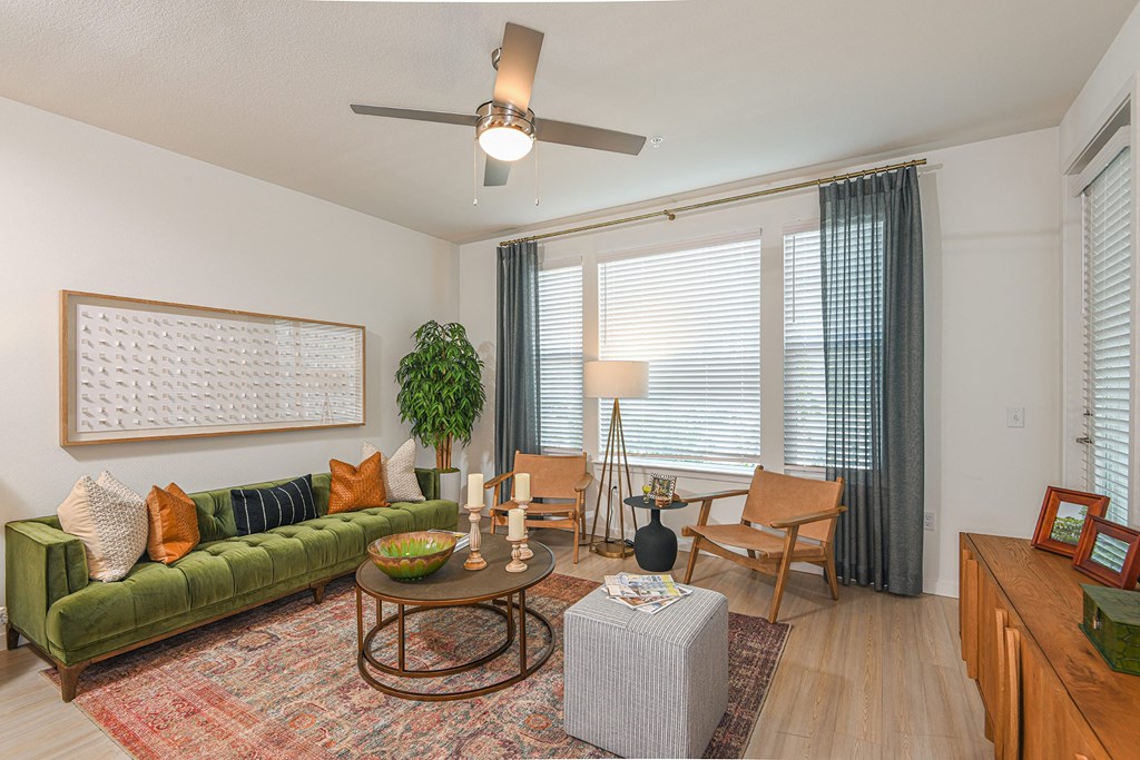 a living room with a green couch and a large window