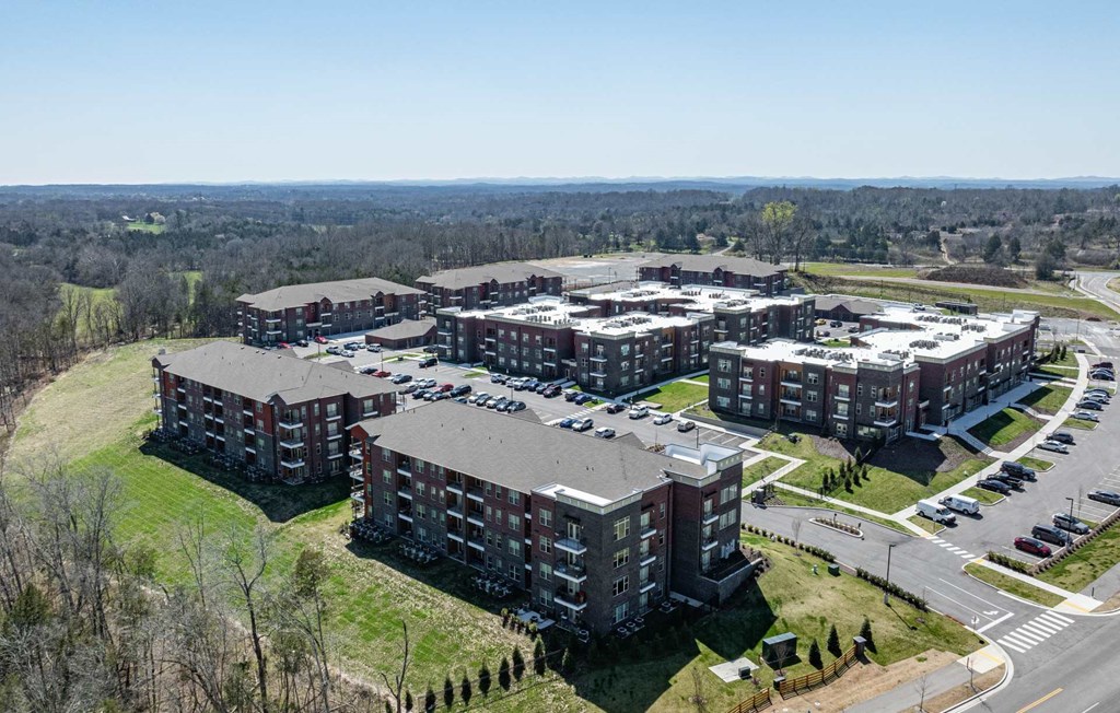 A large, multi-story building complex with a parking lot in front.