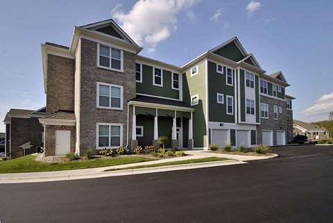 Apartment building with a parking lot in front.