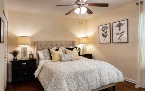 A bedroom with a large bed and a ceiling fan.