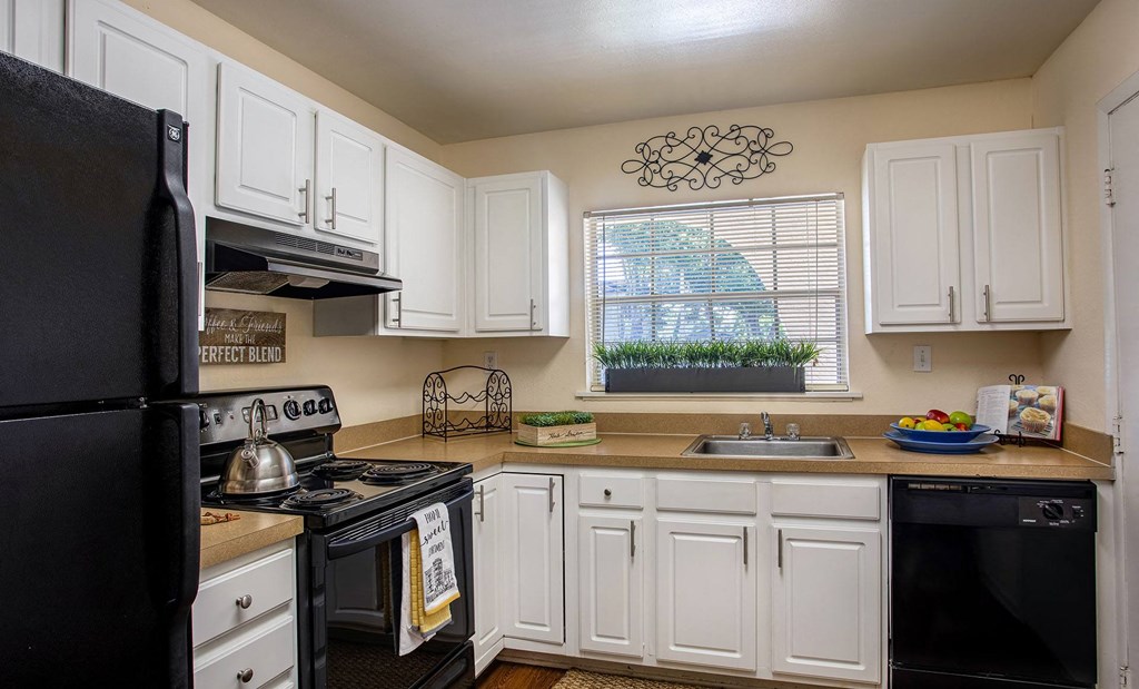 A kitchen with black appliances and white cabinets at Legacy, Tampa, FL, 33603