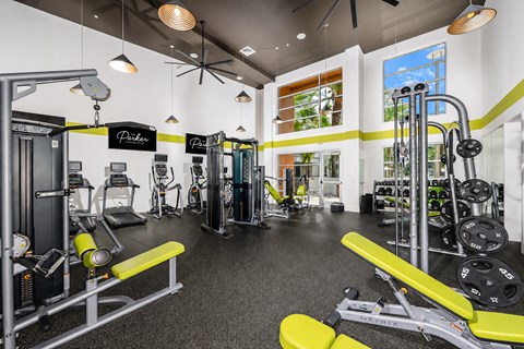 A gym with a variety of equipment including weights and cardio machines.