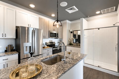 A modern kitchen with granite countertops and stainless steel appliances.