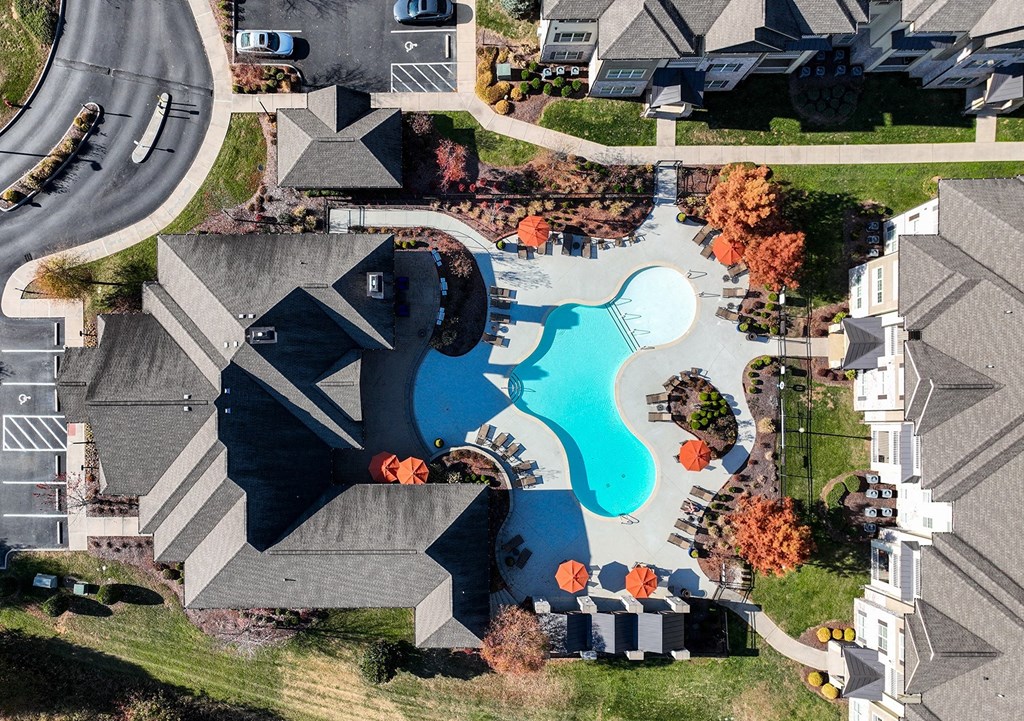 an aerial view of a swimming pool in a neighborhood with houses