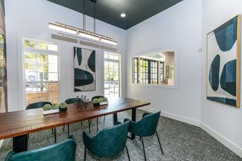 A dining room with a wooden table and green chairs.