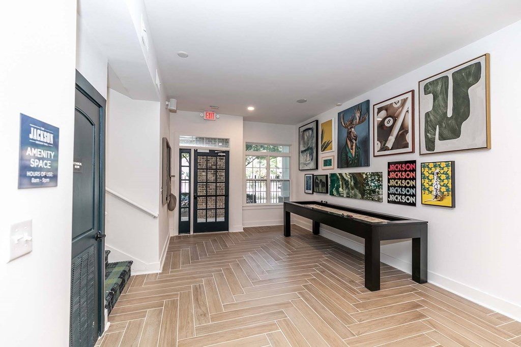 a gallery with paintings on the wall and benches in a room