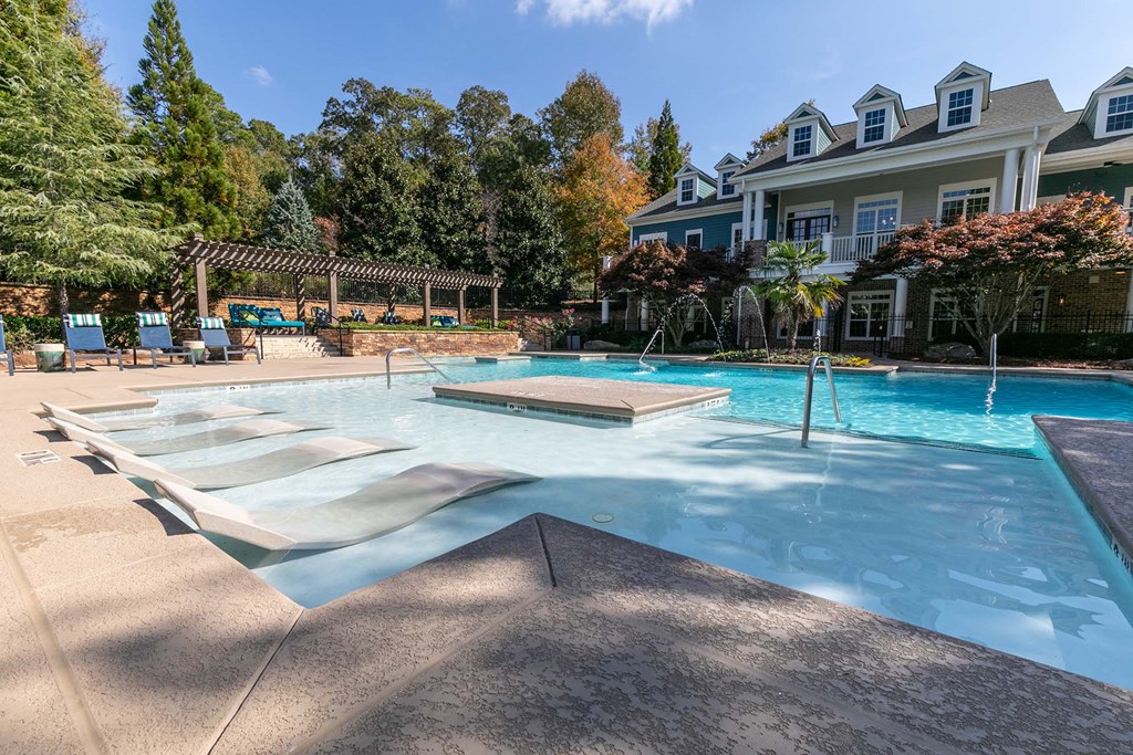 a large swimming pool with a house in the background