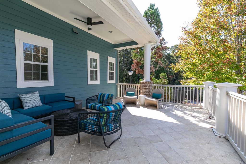 a covered patio with blue furniture and a porch