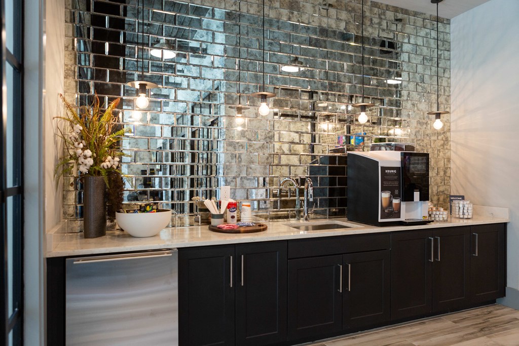 a kitchen with black cabinets and a counter with a sink and a microwave