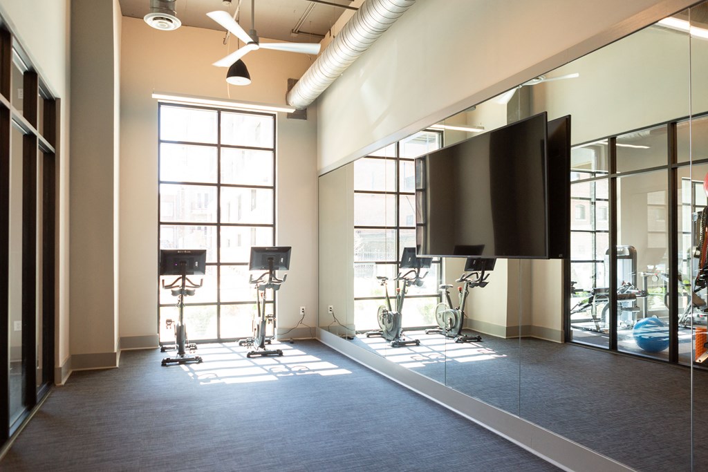 a large room with a tv and video equipment in a room with windows