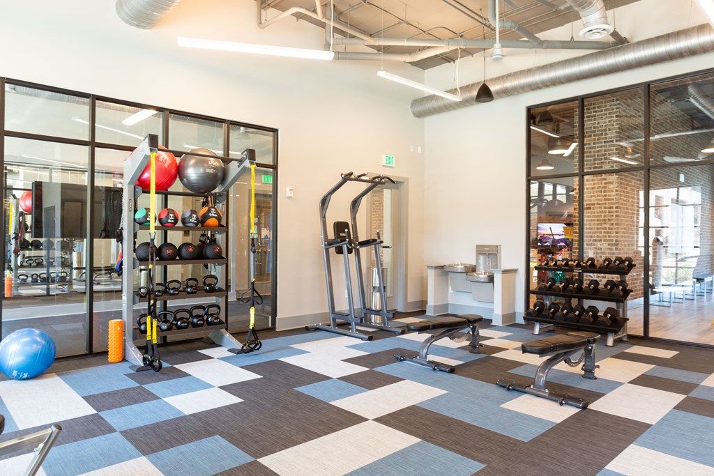 a gym with weights and other exercise equipment at the district at highland village apartments