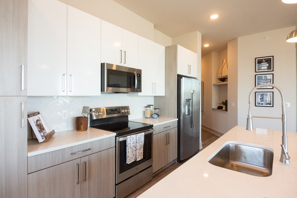 Pet-Friendly Apartments in Downtown Memphis, TN - The Landing - Kitchen with Hardwood Flooring, Stainless Steel Appliances, Quartz Countertops, and Flat-Panel Cabinetry.