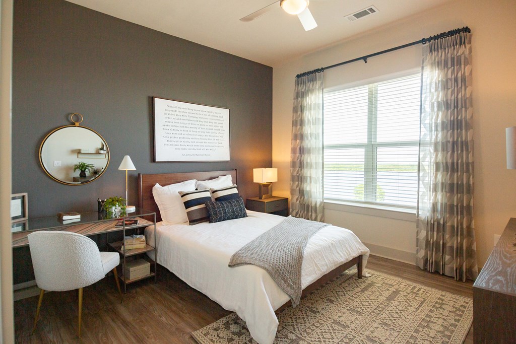 a bedroom with a bed and a desk and a window