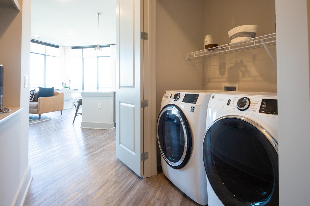a front loading washer and dryer in a living room with a laundry room
