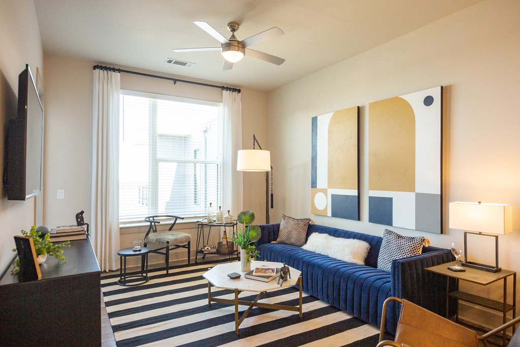 a living room with a blue couch and a ceiling fan