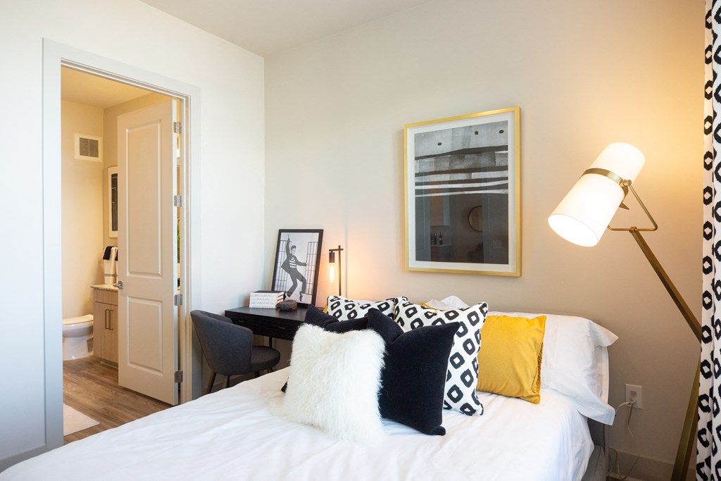 a bedroom with a bed with black and white pillows
