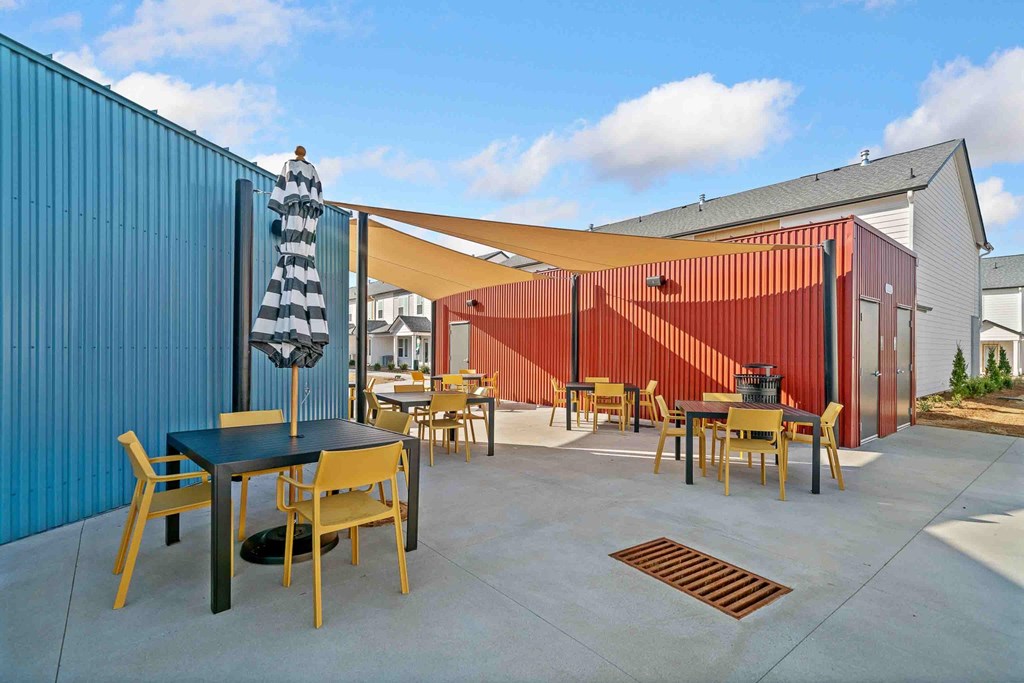 A patio with a table and chairs is surrounded by a blue wall.