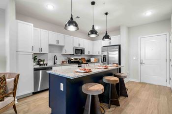 A kitchen with a blue island and white cabinets.